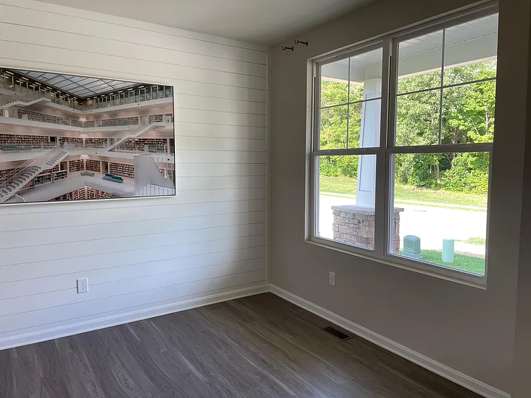 Flex room on main floor has ship lap wall.