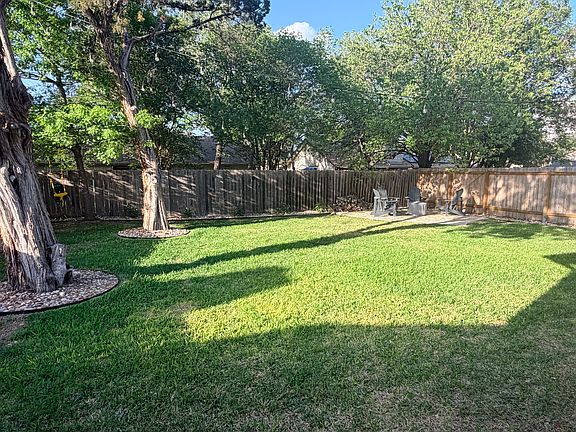 large, grass backyard with back lounge area