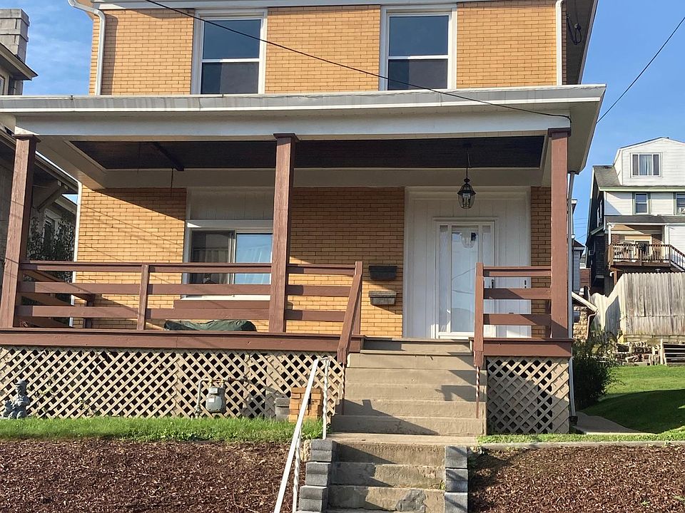 The property from the view of the street. Front porch is large and to be shared with downstairs neighbor. Yard is well maintained.