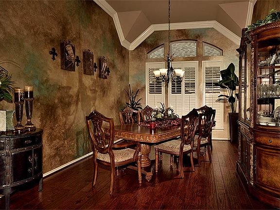 Formal Dining Room has designer painted walls, wood floors, and plantation shutters.  Warm colors draw you in to this intimate setting.