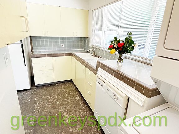 Kitchen features dishwasher and view of carport