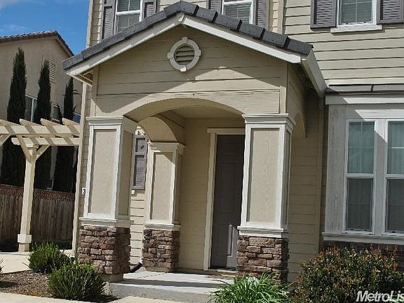 Welcoming covered entry with stone accents to the front of home