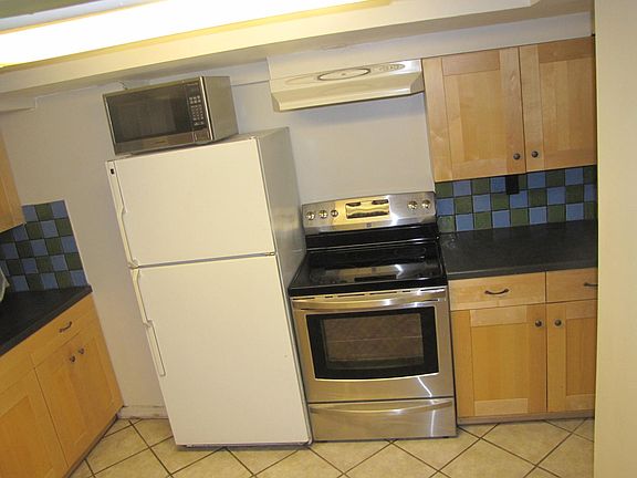 Full sized elec kitchen appliances and Spanish tile.