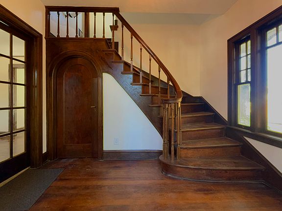 Vintage, craftsman-built entry stairway curves up to the second story apartment, Unit B, also available. French doors to the left open onto Unit A's main floor and lower level.