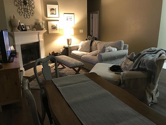 Livingroom w/ wood burning fireplace & vaulted ceiling.