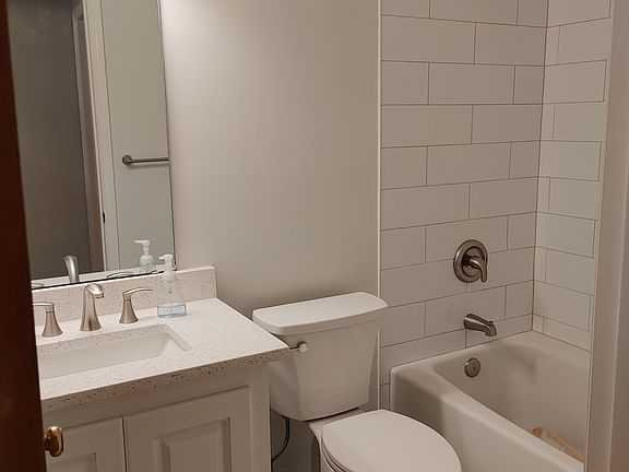 Hall bathroom she has been completely renovated new tub ceramic shower surround new toilet cabinet with granite marble tile on the floor