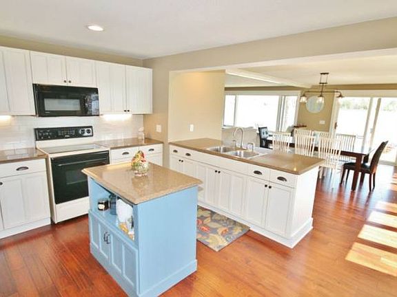 The remodeled kitchen features new white cabinets, quartz counter tops accented with classic white subway tile and illuminated by under counter lights.