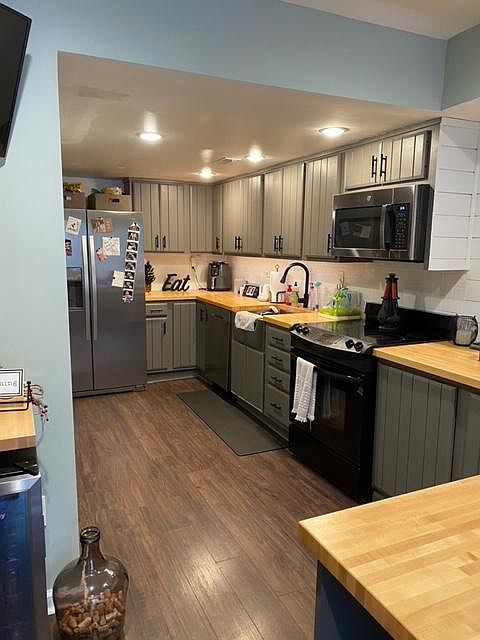 Updated kitchen with stainless steel appliances, butcher block counters, tons of storage, brand new dishwasher, beverage fridge