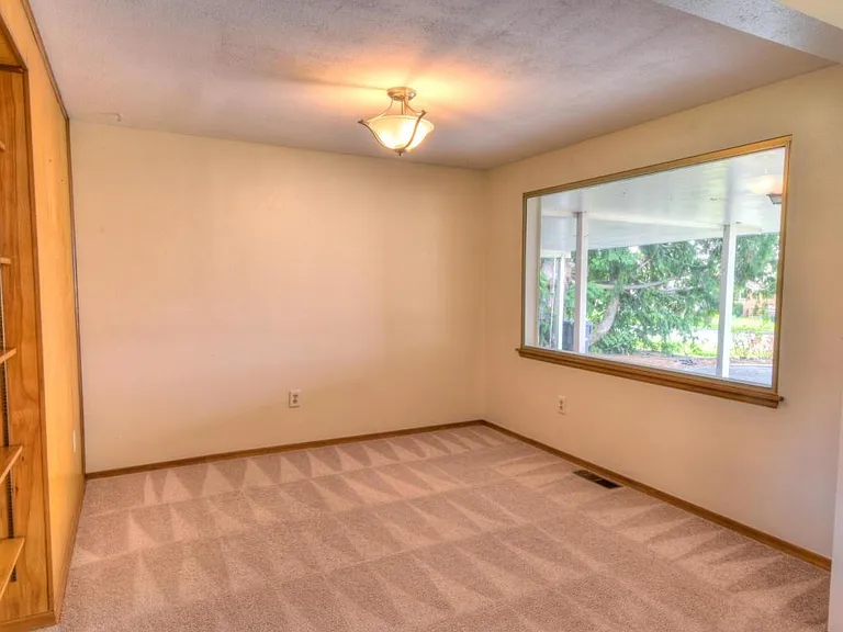 Dining room or den off of living room- great built-in shelving. New energy efficient window treatments not pictured.