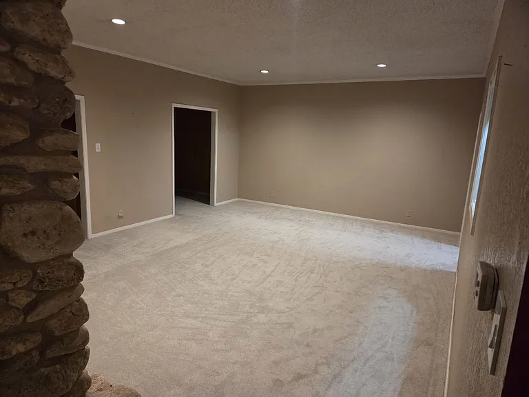 Living room with doors to second living/den, dining room, and third room with wet bar.