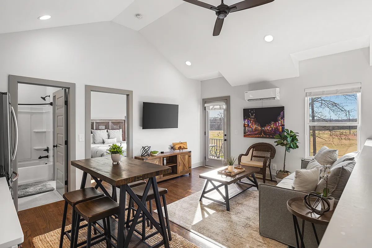Bright, spacious living room filled with natural light, featuring comfortable seating with a sofa bed and a Smart TV with all your favorite streaming apps. - 1101 N 7th St