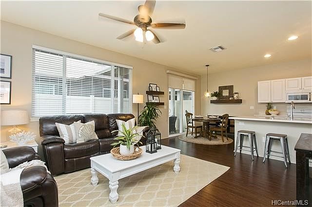 Well maintained open living area, painted in neutral colors, with nicely contrasting, easy care upgraded flooring.
