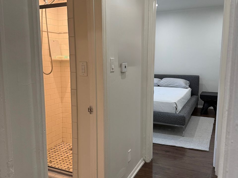 Beautiful hardwood floors flow into meticulously renovated tiled bathroom, retaining charm.