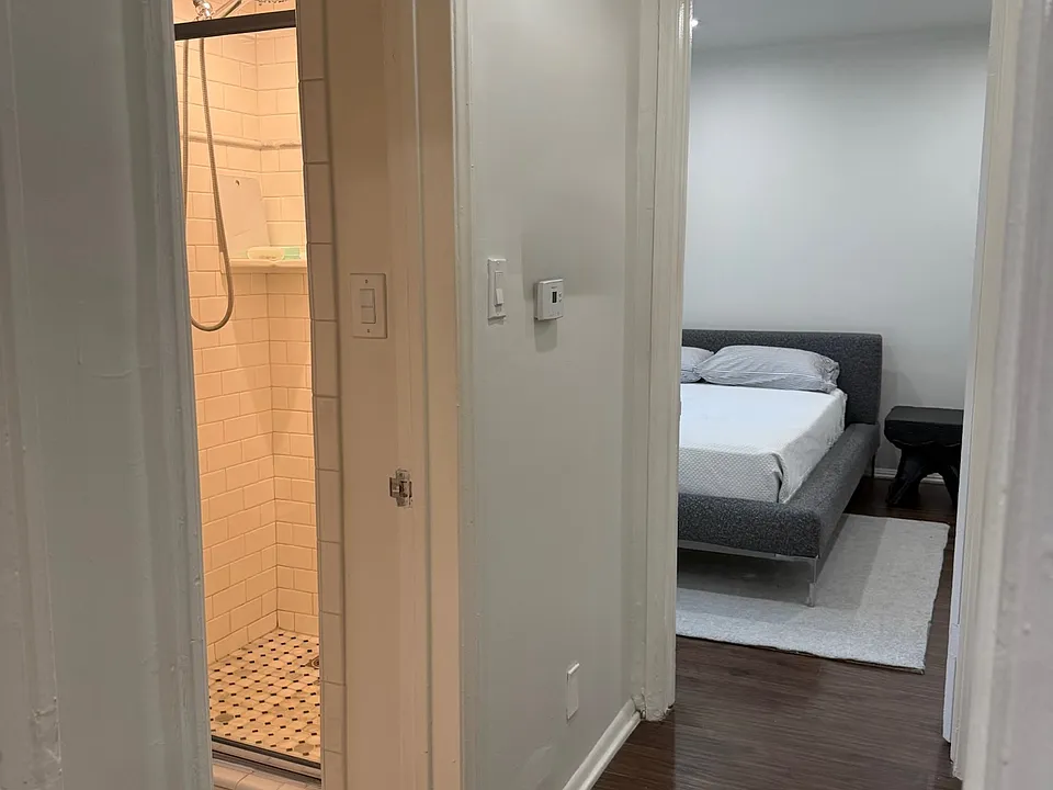 Beautiful hardwood floors flow into meticulously renovated tiled bathroom, retaining charm.