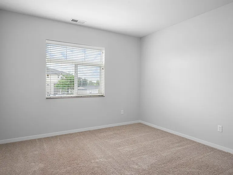 Bright, airy bedroom with soft carpeting, large window, and neutral walls perfect for customization. Bright, airy bedroom with soft carpeting, large window, and neutral walls perfect for customization.