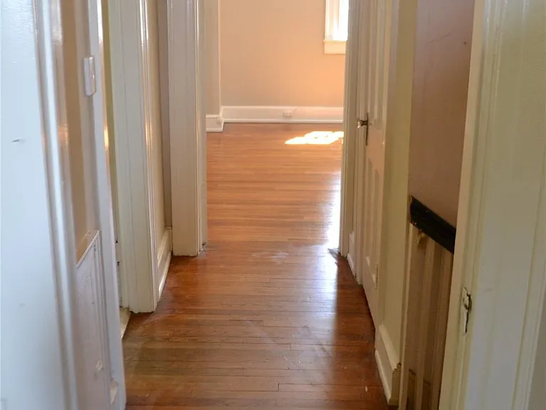 Upstairs hallway between bedrooms (bathroom door to left, stairs and walk-in closet door to right)