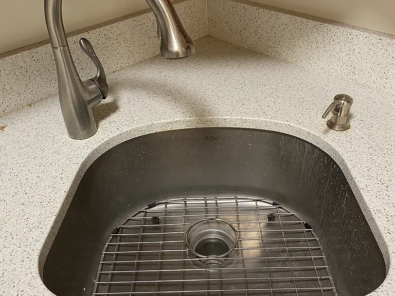 Stainless plumbing fixtures, deep sink and soap dispenser. Quartz counter.
