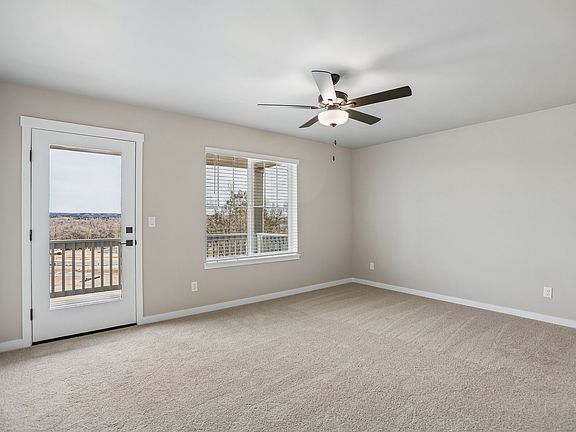 The master bedroom is spacious with a ceiling fan.
