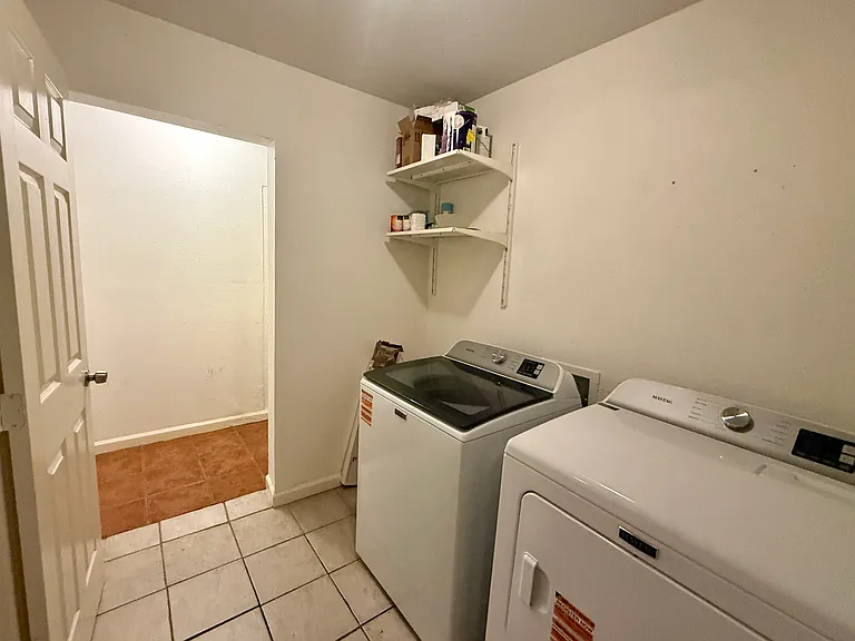 Laundry room with brand new washing machine and dryer (7 and 4 months old, respectively). Shelf w/hooks on wall to R of dryer. Small paint cans for touch ups and HVAC air filters included.
Saltillo tile area visible is storage area.