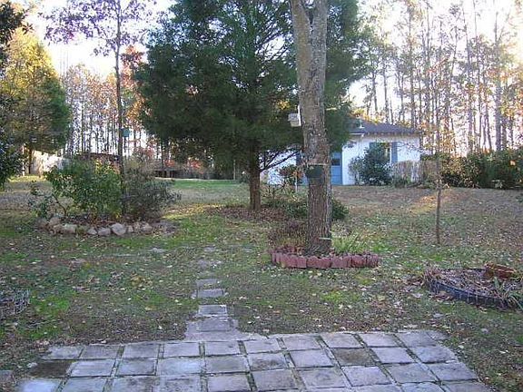 Fenced back yard with a garage/storage building