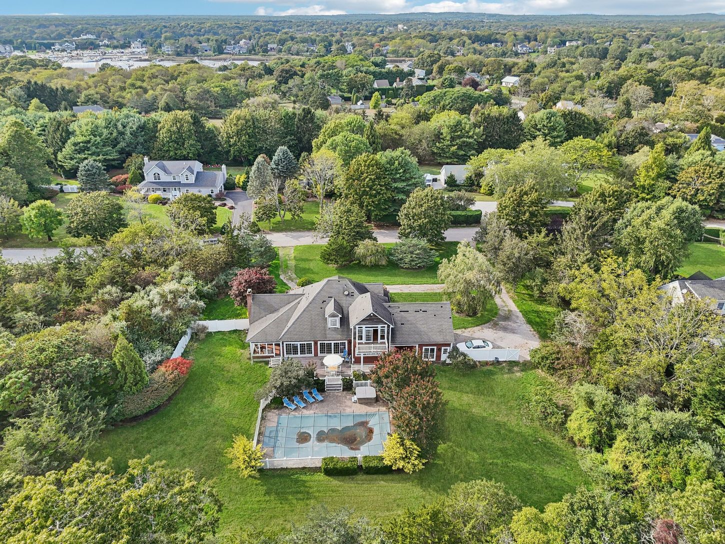 A picturesque view showcasing the swimming pool, sunlit patio, and hot tub.