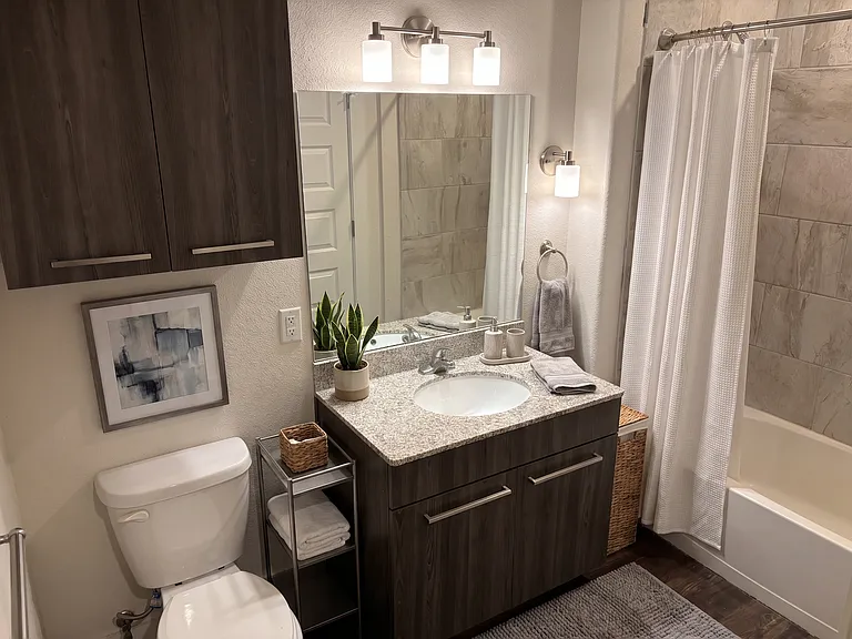 Modern bathroom with lots of cabinet storage, garden bathtub, ceramic tile and granite countertop