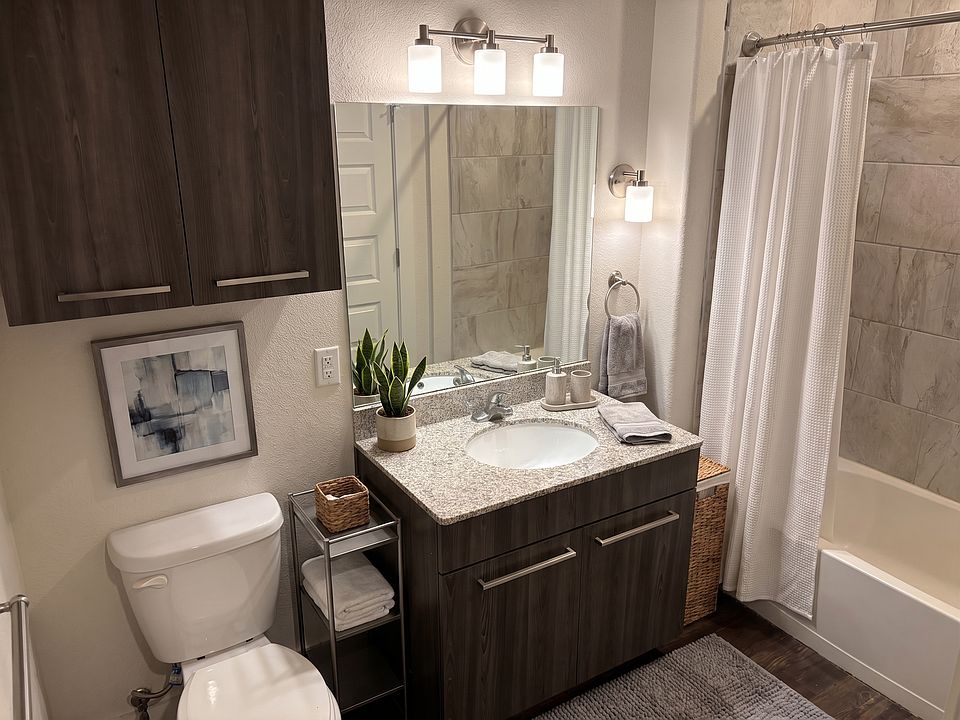 Modern bathroom with lots of cabinet storage, garden bathtub, ceramic tile and granite countertop