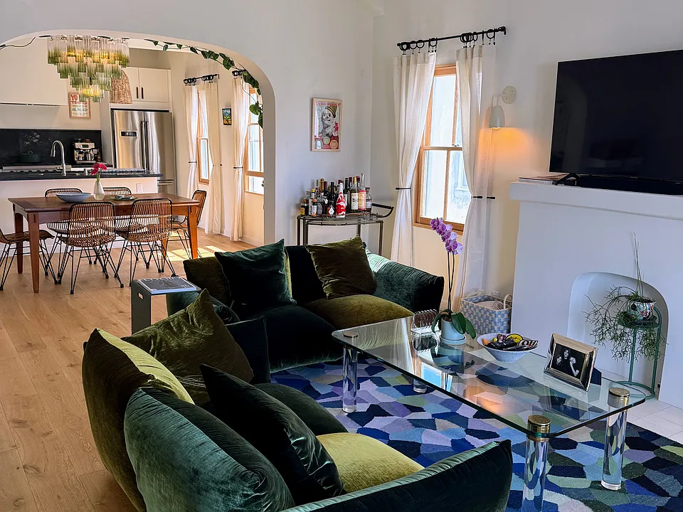 Living room features newly upholstered 1970s B&B Italia sofas, vintage bar cart, two Sonos speakers, and flat screen TV with Apple TV.
