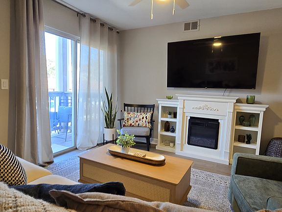 Additional view highlighting the living room''s fireplace and connection to the deck.