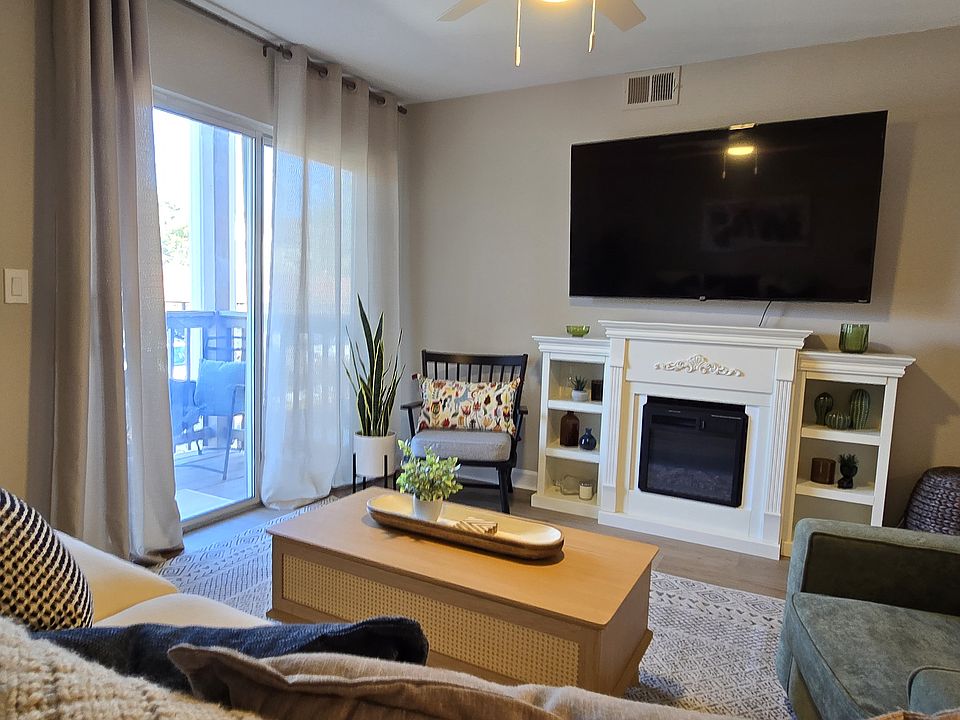 Additional view highlighting the living room''s fireplace and connection to the deck.