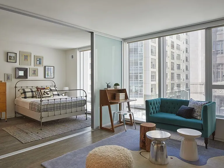 Living area with balcony access and bedroom with sliding barn door and hard surface flooring