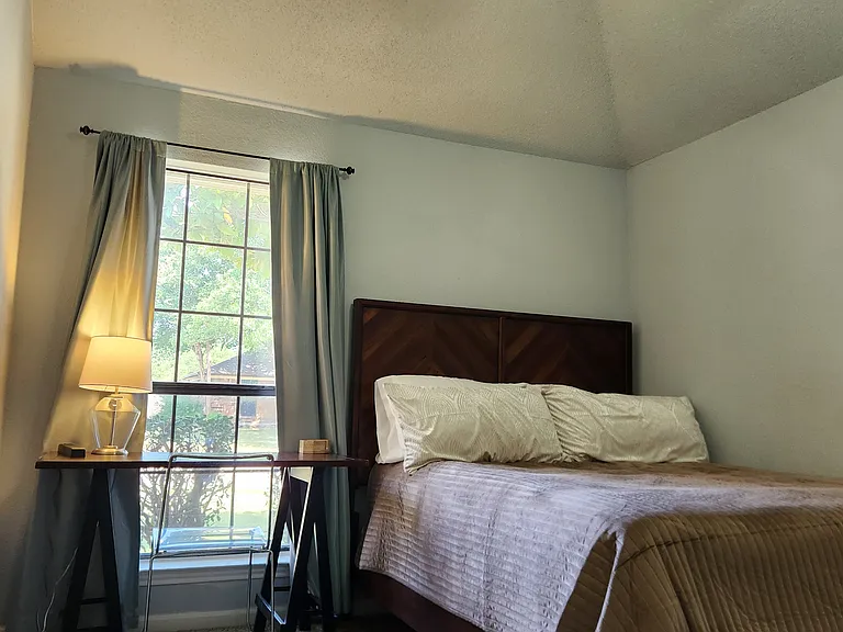 Queen bed, dresser, window view desk with chair, closet.