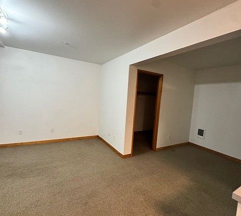 standing by refrigerator looking out into living area toward closet