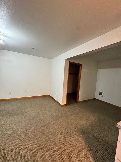 standing by refrigerator looking out into living area toward closet