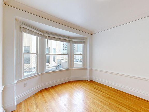 Bright room with a wood-like flooring and a large window offering natural light