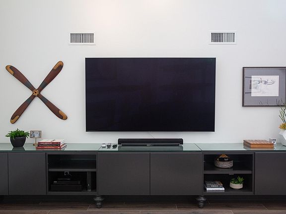The custom living room entertainment center is 15' long with an 82" Samsung HD TV equipped with Sonos sound bar and sub woofer