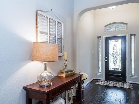 A charming entryway is light and airy! An arched window, thin sidelights and a custom leaded glass front door allows natural light to flow into the space!