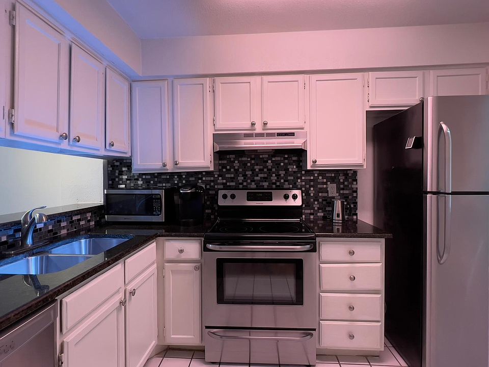 Wide angle view of left and right side of the L-shaped kitchen.