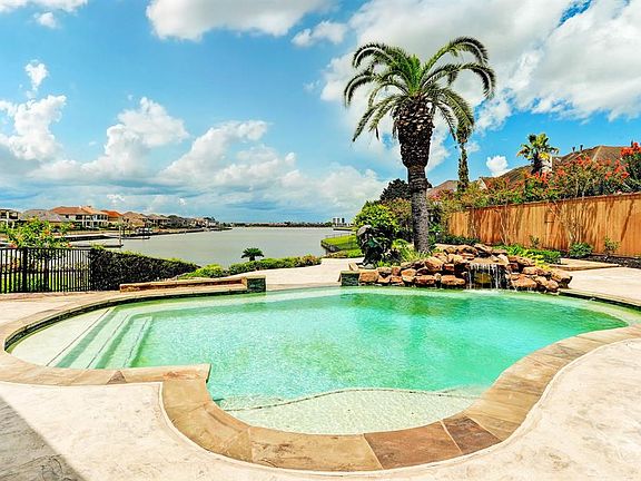 SPECTACULAR OUTDOOR OASIS INCLUDES A COVERED VERANDA WITH KITCHEN, FIREPLACE, TV AND TERRACED PATIOS FOR ENTERTAINING.