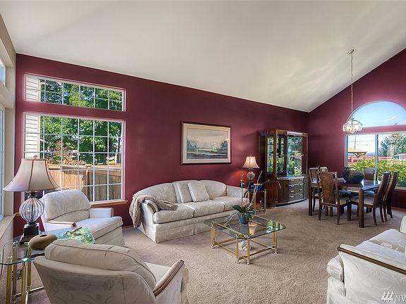 Living Room with lots of custom windows. Vaulted ceilings. Abundance of Natural light.