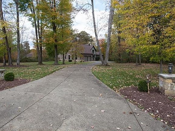 The exposed aggregate concrete driveway with lighted entrance and front walkway with natural stone w