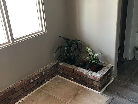 Entry way with tile and plank flooring, small planter, and all new paint.