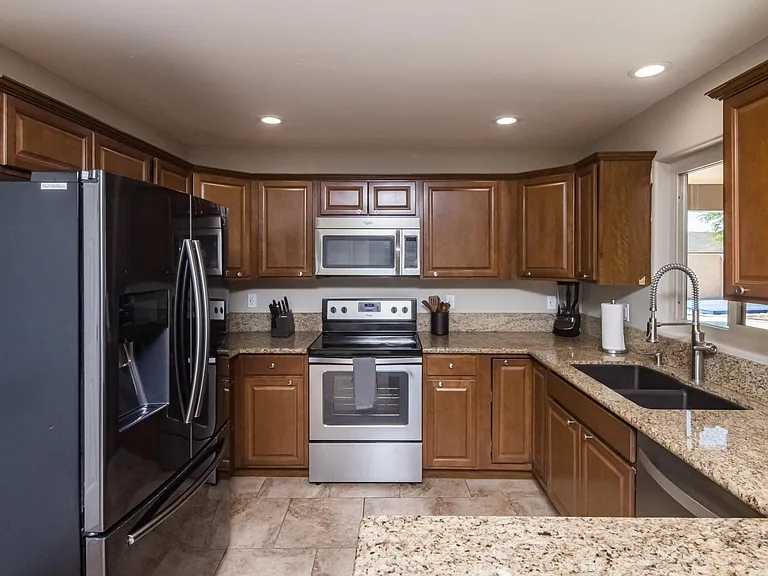 Well-appointed kitchen featuring granite countertops, stainless steel appliances, and ample cabinet storage.