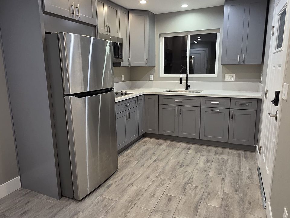 Modern fully equipped kitchen. Feature stainless steel appliances, such as Refrigerator microwave oven and stove top appliance.