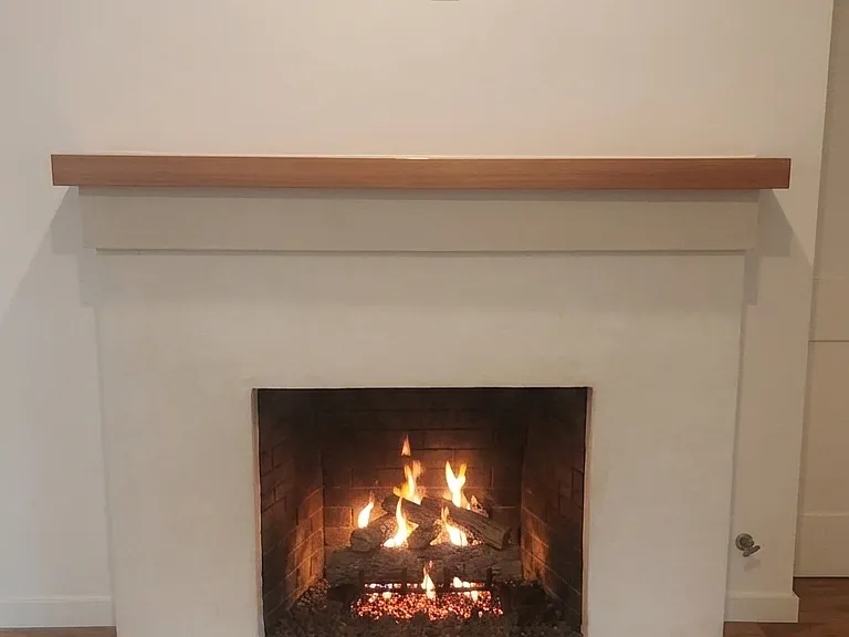 Gas-powered fireplace logs. Custom milled wood mantel. Wall AV connectors with (1) coaxial, (2) HDMI ports & power above the mantel.