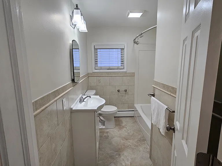 Updated bathroom with Italian marble tile and lighted Fan.