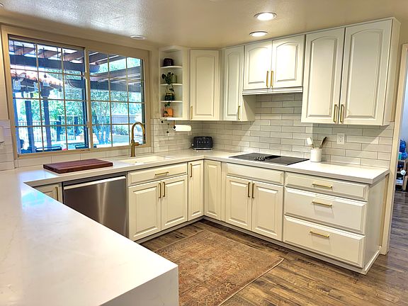 A picture window above the sink overlooks the spectacular backyard entertainment deck, seamlessly blending indoor and outdoor living.