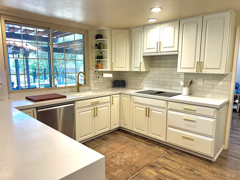 A picture window above the sink overlooks the spectacular backyard entertainment deck, seamlessly blending indoor and outdoor living.