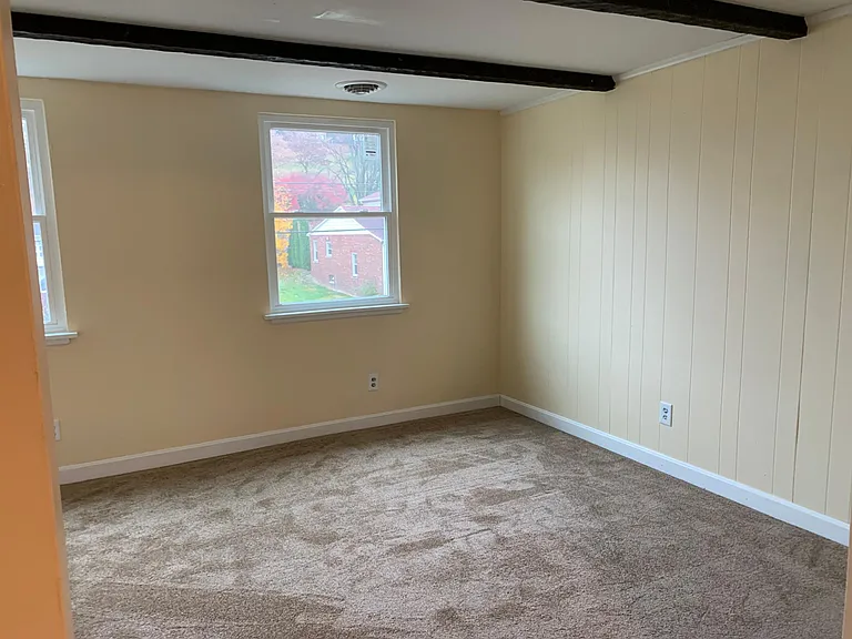 Spacious living area with exposed beams.