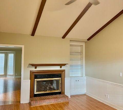 Den with vaulted ceiling, new ceiling fan, and fireplace.